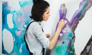 A woman deeply immersed in painting, embodying the essence of art therapy for ADHD and anxiety relief, offered in Gainesville, FL, for college students and adults seeking transformative healing.