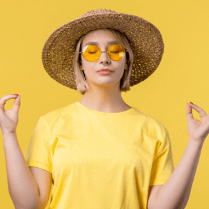 Smiling woman standing against a yellow background, feeling confident and unique after benefiting from ADHD therapy in Wilmington, NC